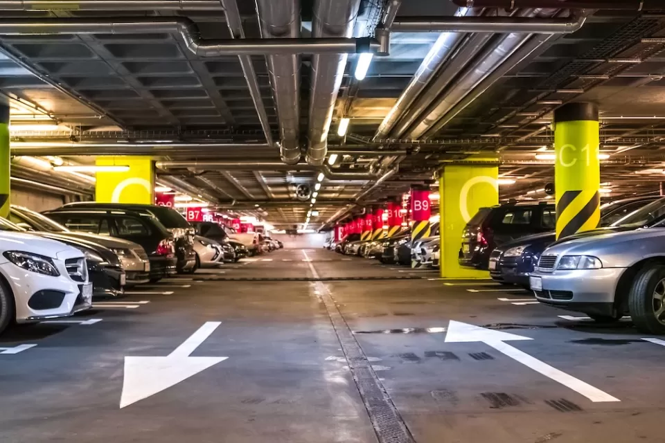 Interior of large parking garage full of cars.